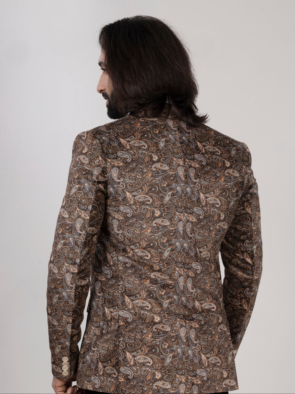 Man wearing a patterned jacket on a plain background