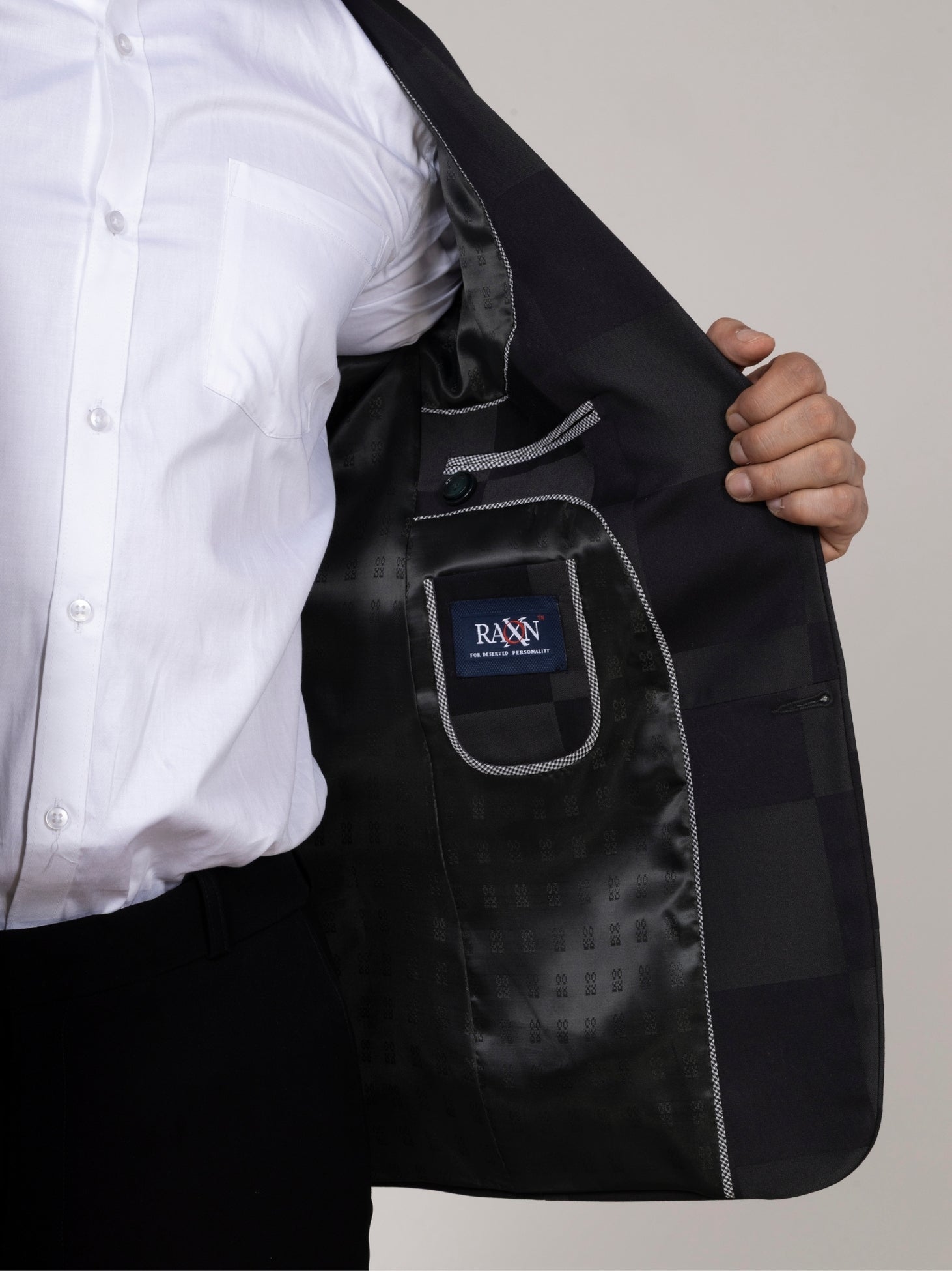 Black blazer with a visible brand logo over a white shirt on a neutral background