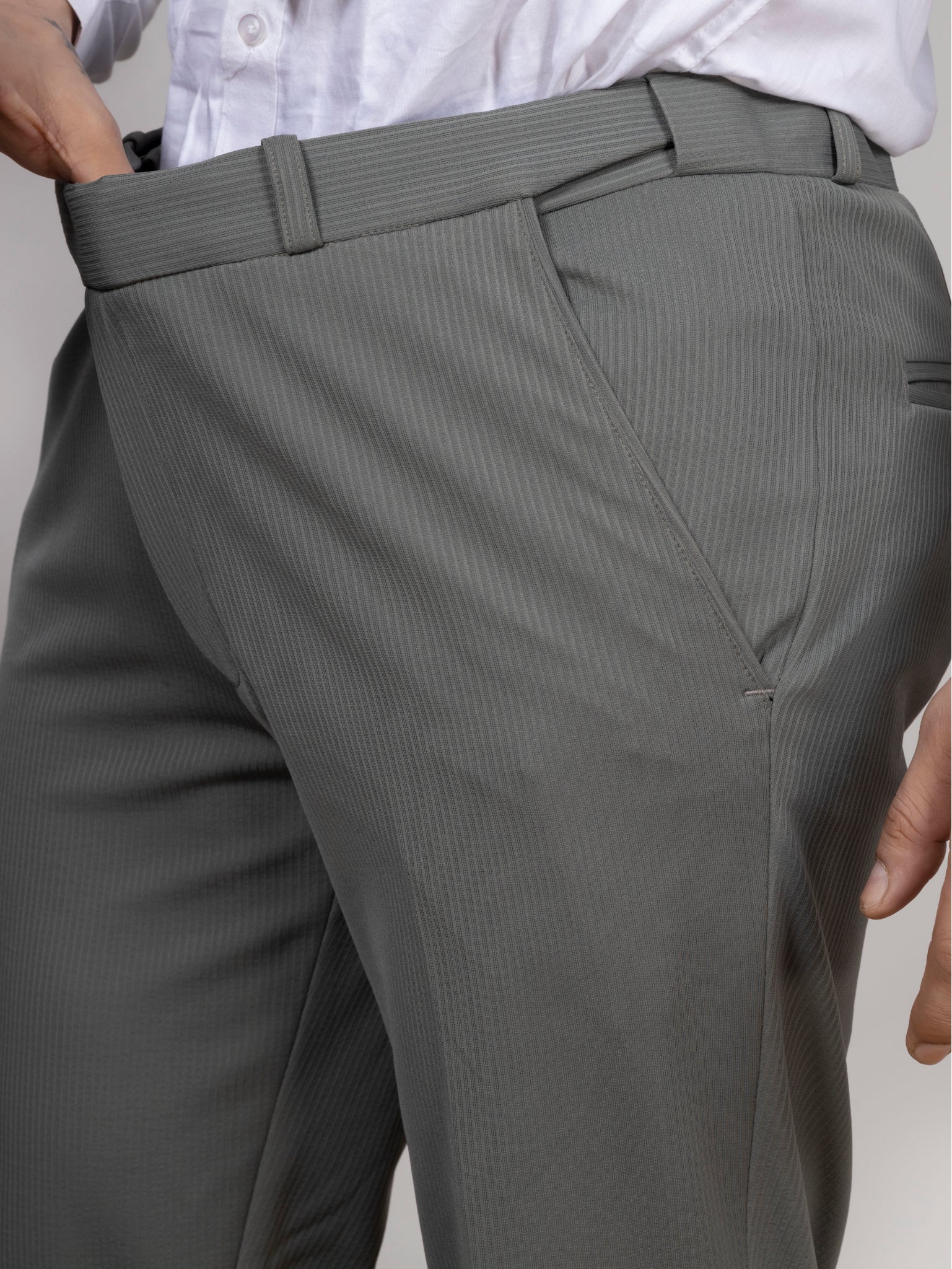 Gray pinstripe dress pants with a white shirt on a neutral background