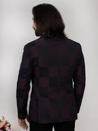 Man wearing a dark suit jacket against a plain background