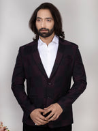 Man wearing a dark suit and white shirt against a plain background