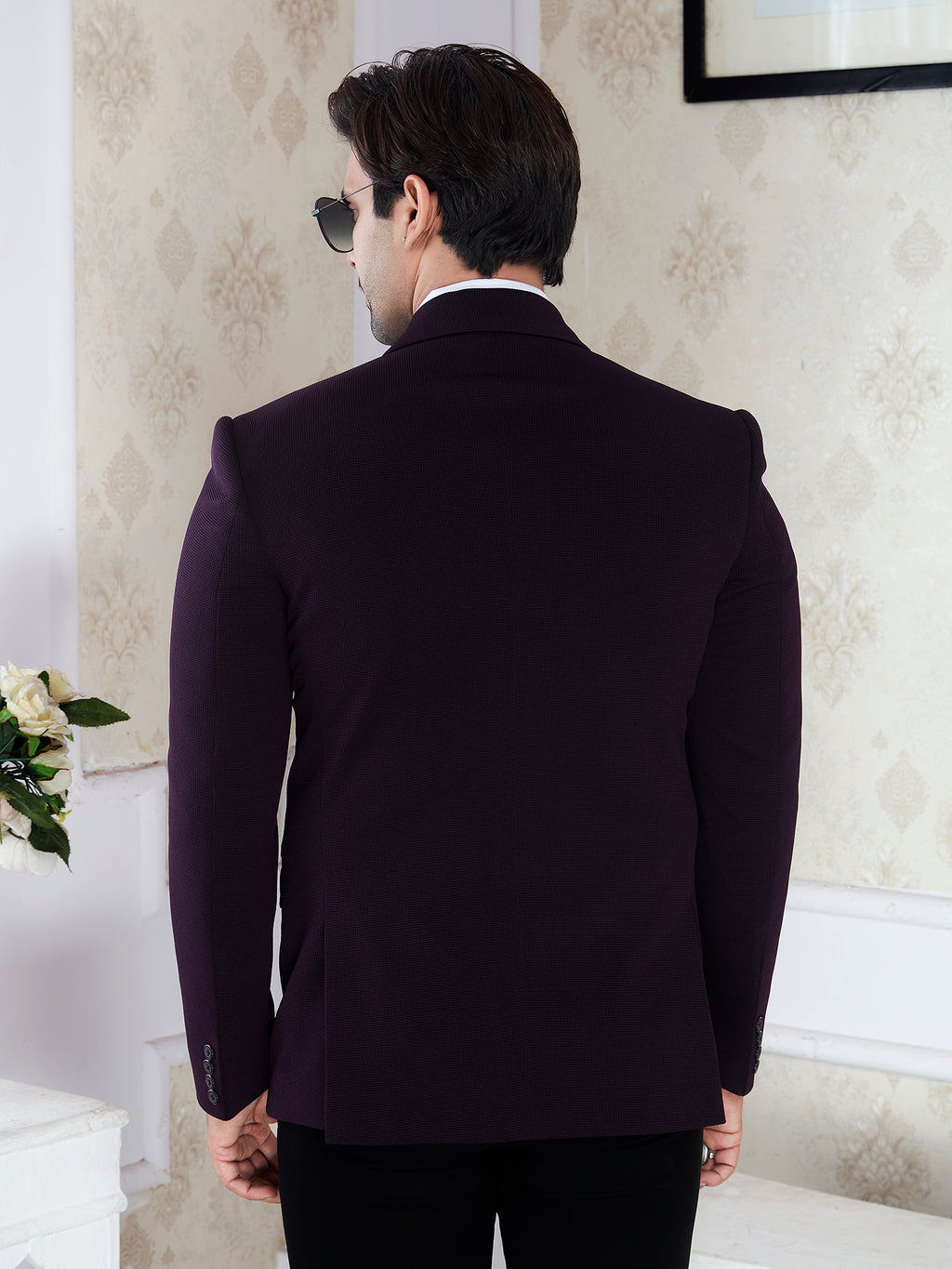 Man wearing a dark purple suit jacket in an indoor setting