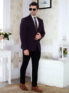 Man in a dark suit with sunglasses standing in a decorated room.