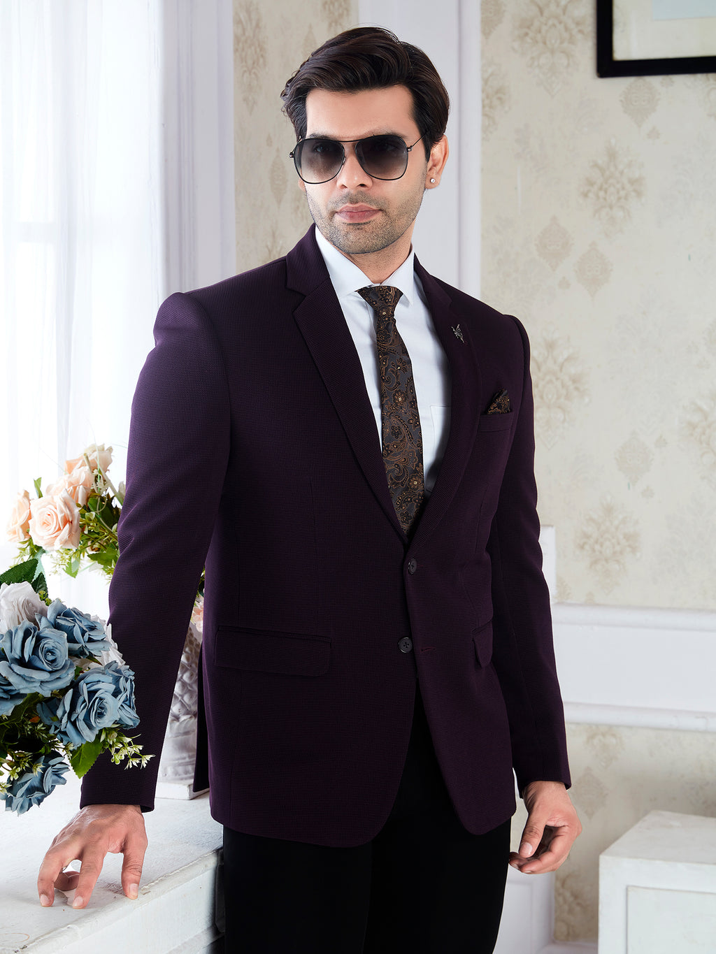 Man wearing a dark suit with sunglasses indoors