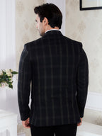 Man wearing a black checkered suit jacket in an indoor setting