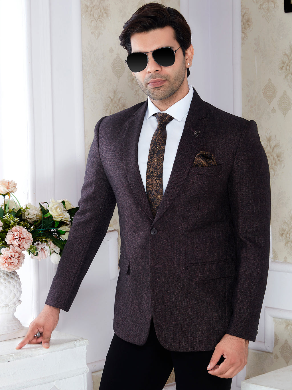 Man in a dark suit with sunglasses standing in an elegant room with floral decor.