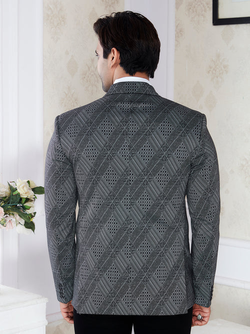 Man wearing a patterned gray blazer in an indoor setting