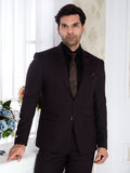 Man wearing a black suit with a patterned tie in a well-lit room.