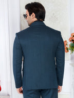 Man wearing a navy blue suit in an indoor setting with decorative elements.